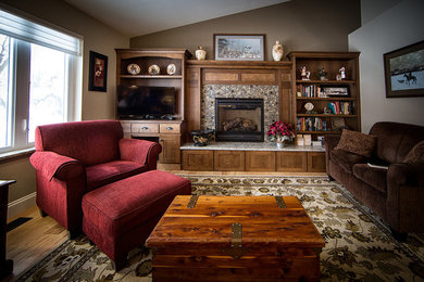 Example of a mid-sized transitional open concept light wood floor and brown floor living room library design in Other with brown walls, a standard fireplace, a tile fireplace and a tv stand
