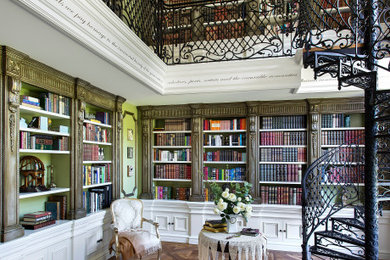 Ejemplo de biblioteca en casa abierta extra grande con paredes verdes, suelo de madera oscura, suelo marrón y panelado