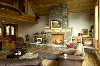 Foto de salón para visitas abierto rústico grande sin televisor con paredes grises, suelo de madera clara, todas las chimeneas y marco de chimenea de piedra