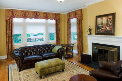 Mid-sized elegant enclosed medium tone wood floor living room photo in New York with brown walls, a standard fireplace and a wood fireplace surround