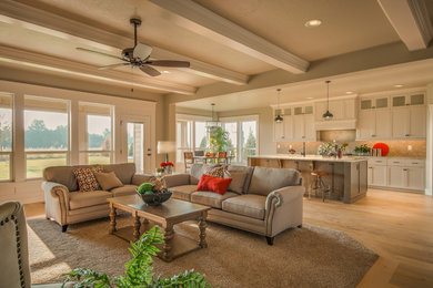Example of a large classic formal and open concept light wood floor living room design in Boise with beige walls, a standard fireplace, a wood fireplace surround and a media wall