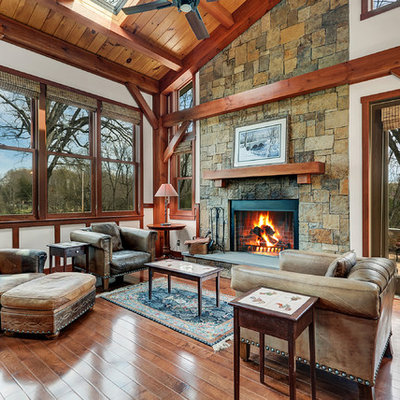 Example of a mid-sized mountain style open concept and formal brown floor and dark wood floor living room design in DC Metro with a stone fireplace, white walls and a standard fireplace