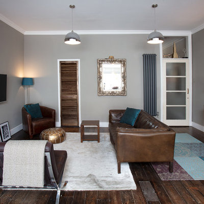 Inspiration for a mid-sized contemporary enclosed dark wood floor and brown floor living room remodel in London with gray walls and a wall-mounted tv