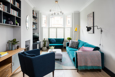 Abgetrenntes Klassisches Wohnzimmer mit grauer Wandfarbe, braunem Holzboden, Kamin, freistehendem TV und braunem Boden in London