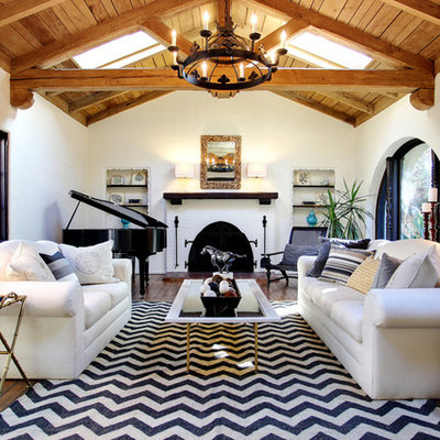 Example of a mountain style medium tone wood floor living room design in Los Angeles with white walls, a standard fireplace and a brick fireplace