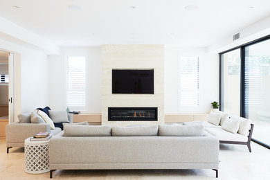 Inspiration för moderna vardagsrum, med vita väggar, en bred öppen spis och en väggmonterad TV