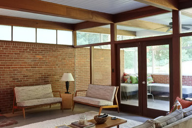 Inspiration for a mid-sized mid-century modern open concept living room remodel in Atlanta with a wood stove and a brick fireplace