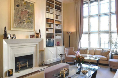 Example of a large classic dark wood floor living room library design in New York with a standard fireplace and a stone fireplace