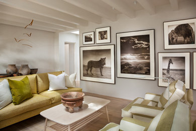 Foto de salón para visitas abierto contemporáneo de tamaño medio con paredes blancas, suelo de madera clara, todas las chimeneas, marco de chimenea de yeso y suelo marrón