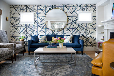 Modernes Wohnzimmer mit grauer Wandfarbe, braunem Holzboden, Kamin und braunem Boden in Calgary
