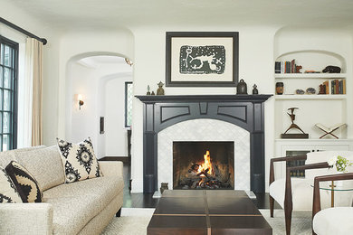 グランドラピッズにある広いトランジショナルスタイルのおしゃれなリビング (ベージュの壁、濃色無垢フローリング、標準型暖炉、タイルの暖炉まわり、テレビなし、茶色い床) の写真
