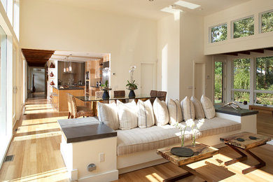 Immagine di un grande soggiorno design aperto con pareti beige, pavimento in bambù, camino classico, cornice del camino in pietra, nessuna TV e sala formale