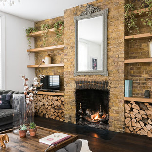 Design ideas for a large mediterranean open plan living room in London with dark hardwood flooring, white walls, a standard fireplace, a brick fireplace surround, a freestanding tv and brown floors.