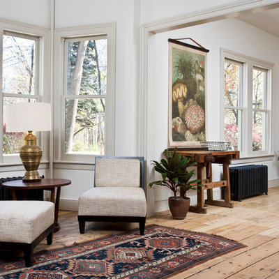Ornate medium tone wood floor and brown floor living room photo in New York with white walls