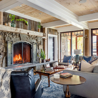 Inspiration for a large rustic open concept beige floor and medium tone wood floor living room remodel in New York with brown walls, a standard fireplace, a stone fireplace and no tv