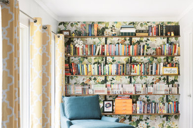 Ejemplo de biblioteca en casa abierta clásica renovada de tamaño medio sin televisor con paredes multicolor, suelo laminado y suelo marrón
