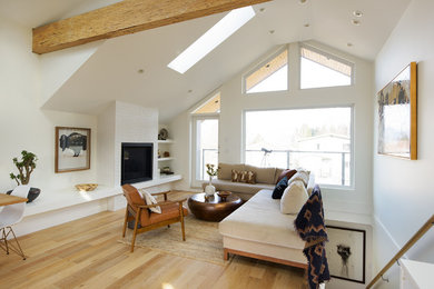 Example of a large danish open concept light wood floor living room design in Vancouver with white walls, a standard fireplace and a tile fireplace