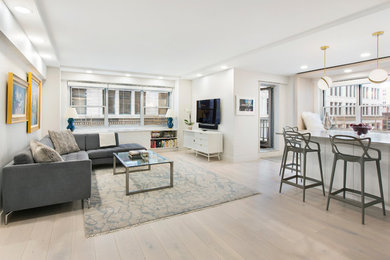 Large minimalist open concept beige floor living room photo in New York with white walls and a wall-mounted tv