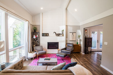 Example of an eclectic medium tone wood floor and brown floor living room design in Seattle with a standard fireplace
