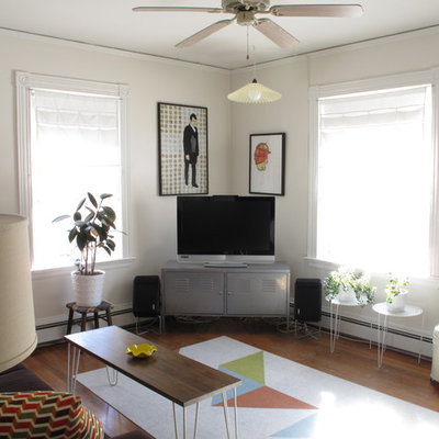 Living room - eclectic medium tone wood floor living room idea in Boston with white walls and a tv stand