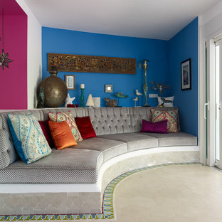 Inspiration for a mediterranean living room in Sussex with blue walls and beige floors.