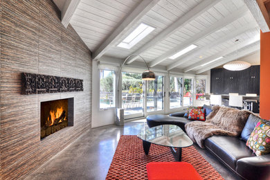Mid-century modern open concept concrete floor living room photo in Orange County with white walls, a corner fireplace, a tile fireplace and a wall-mounted tv