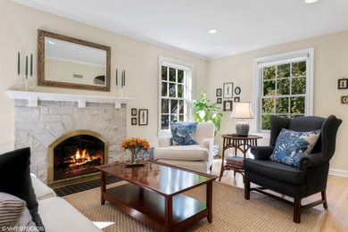 Example of a classic living room design in Chicago with beige walls, a standard fireplace and a stone fireplace