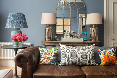 Ispirazione per un soggiorno chic chiuso con pareti blu, parquet chiaro e pavimento beige