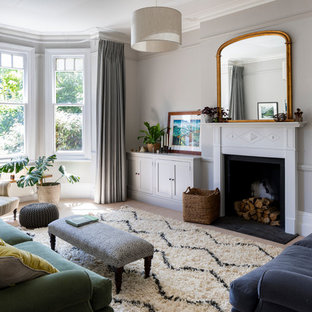 Photo of a medium sized contemporary formal enclosed living room in London with grey walls, carpet, a standard fireplace, a metal fireplace surround and beige floors.