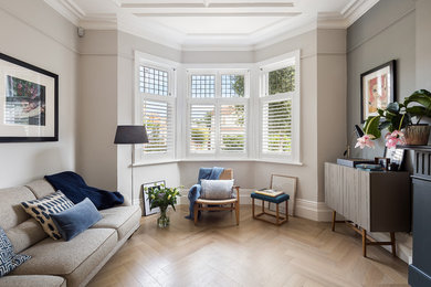 Diseño de salón para visitas escandinavo sin chimenea y televisor con paredes beige y suelo de madera clara