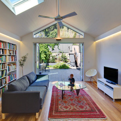 Living room - mid-sized contemporary open concept light wood floor living room idea in Sydney with white walls and a tv stand