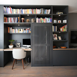 Photo of a small modern living room in London with grey walls, light hardwood flooring, no fireplace and a wall mounted tv.