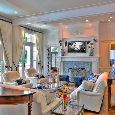 Mid-sized elegant enclosed and formal medium tone wood floor living room photo in New York with a standard fireplace, a stone fireplace, a wall-mounted tv and white walls