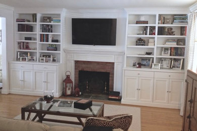Elegant open concept medium tone wood floor living room photo in Philadelphia with beige walls, a standard fireplace, a tile fireplace and a wall-mounted tv