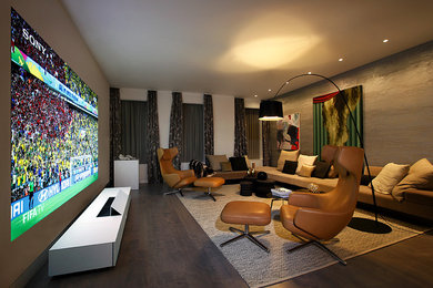 Modelo de salón minimalista grande sin chimenea y televisor con paredes blancas y suelo de madera oscura