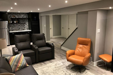 Imagen de salón cerrado minimalista de tamaño medio sin chimenea con paredes grises, suelo de madera en tonos medios, televisor colgado en la pared y suelo gris