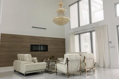 マイアミにある高級な広いコンテンポラリースタイルのおしゃれなリビング (白い壁、磁器タイルの床、横長型暖炉、木材の暖炉まわり、テレビなし、白い床) の写真