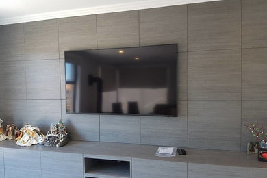 Пример оригинального дизайна: большая гостиная комната в стиле модернизм с серыми стенами и телевизором на стене
