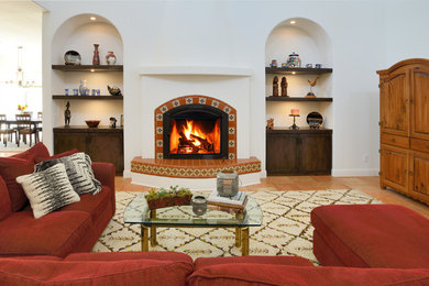 Inspiration for a mediterranean formal and open concept terra-cotta tile and orange floor living room remodel in Sacramento with a tile fireplace, white walls and a concealed tv