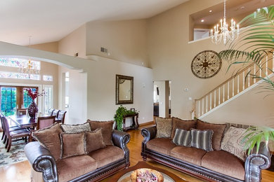 Foto de salón para visitas tipo loft clásico grande sin televisor con paredes beige, suelo laminado y suelo marrón