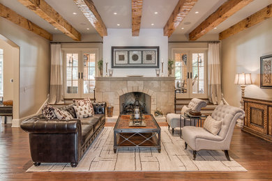 Mediterranean formal living room in Nashville with beige walls, medium hardwood flooring, a standard fireplace, a tiled fireplace surround and no tv.
