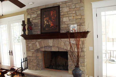 Mid-sized elegant medium tone wood floor and brown floor living room photo in Chicago with beige walls, a standard fireplace and a stone fireplace