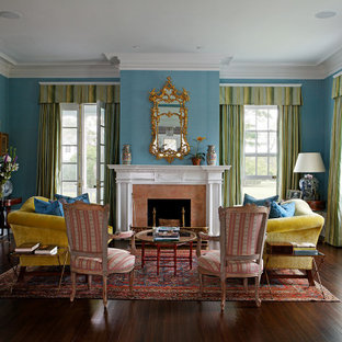 Design ideas for a classic enclosed living room in London with blue walls, dark hardwood flooring, a standard fireplace, a stone fireplace surround and brown floors.