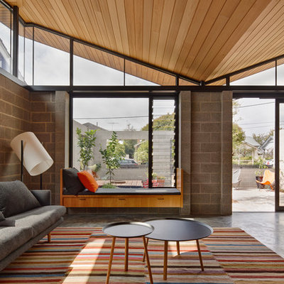1960s formal and open concept concrete floor living room photo in Melbourne with gray walls