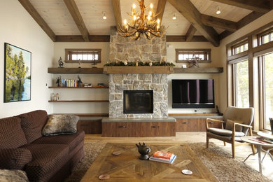 Exemple d'un grand salon montagne ouvert avec une salle de réception, un mur beige, parquet clair, une cheminée standard, un manteau de cheminée en pierre, un téléviseur encastré et un sol beige.