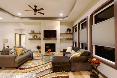 他の地域にある高級な中くらいなトランジショナルスタイルのおしゃれなリビング (白い壁、淡色無垢フローリング、標準型暖炉、据え置き型テレビ、茶色い床) の写真