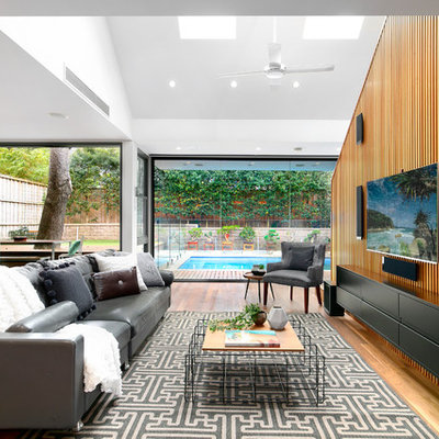Inspiration for a mid-sized contemporary open concept medium tone wood floor and brown floor living room remodel in Sydney with white walls, no fireplace and a wall-mounted tv