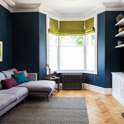 Trendy light wood floor living room photo in London with blue walls