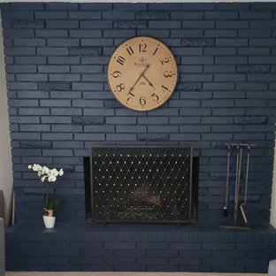 Klassisches Wohnzimmer mit blauer Wandfarbe, Teppichboden, Kamin, Kaminumrandung aus Backstein, beigem Boden und Ziegelwänden in Portland