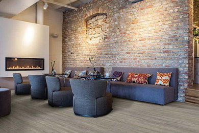 オレンジカウンティにある高級な広いインダストリアルスタイルのおしゃれなリビング (白い壁、無垢フローリング、標準型暖炉、漆喰の暖炉まわり、テレビなし、茶色い床) の写真